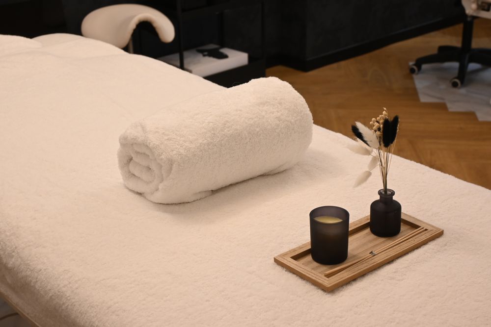 Rolled towel, candle and dried flowers on a massage table