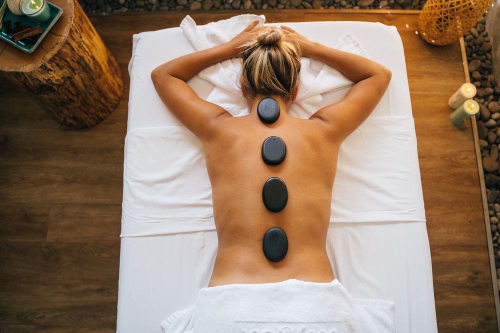 Smooth hot stones placed along a client's spine