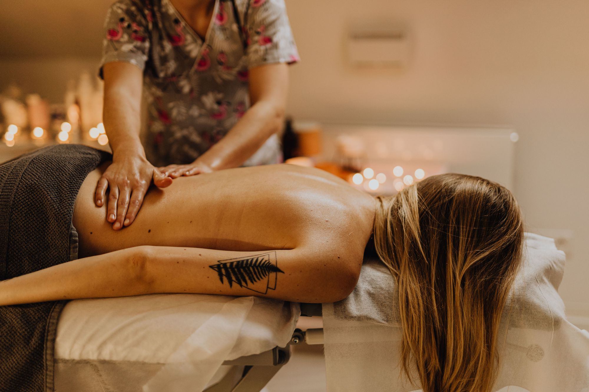 Woman relaxing face down during a candlelit back massage