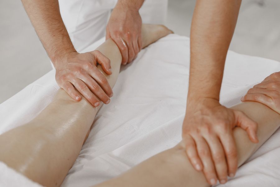Therapist's hands performing gentle leg massage